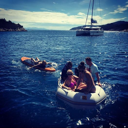A group of travelers on a sailing holiday in Croatia, enjoying the beautiful coastline and crystal-clear waters