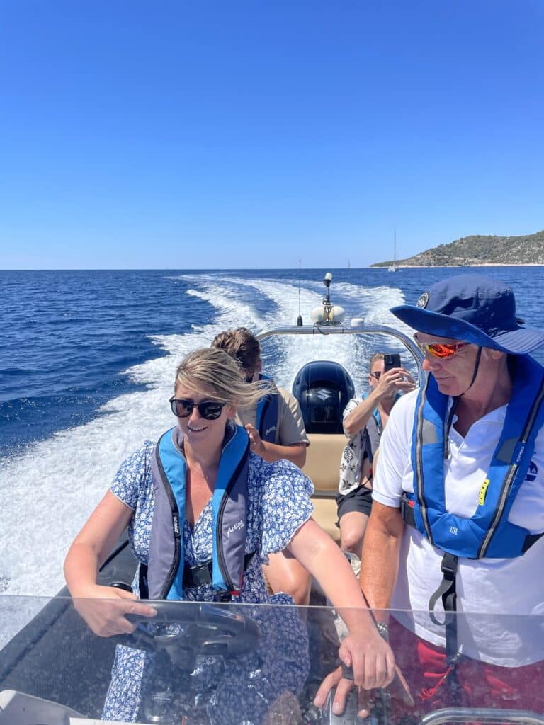 A group of friends laughing and cheering while powerboating across the Adriatic Sea.