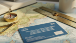A close-up of an RYA ICC certification document resting on a navigation chart with a pair of dividers.