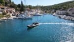 A modern powerboat navigating through a busy marina in Milna during an RYA Powerboat Level 2 training course.