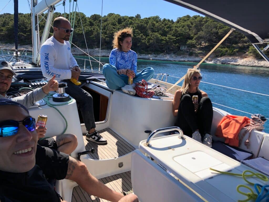 Yacht charter in Croatia. A happy group of friends on the deck of a sailing yacht in a turquoise bay in Croatia.
